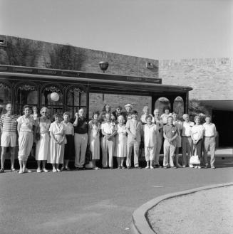 Large unidentified group outside of a brick building