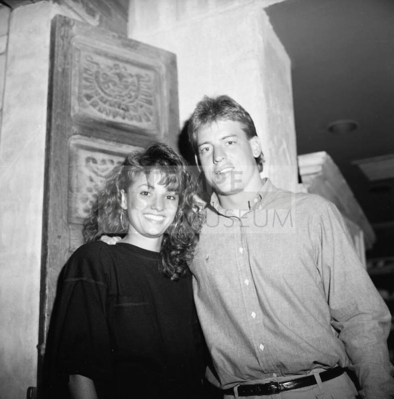 young man and woman pose in front of carved door
