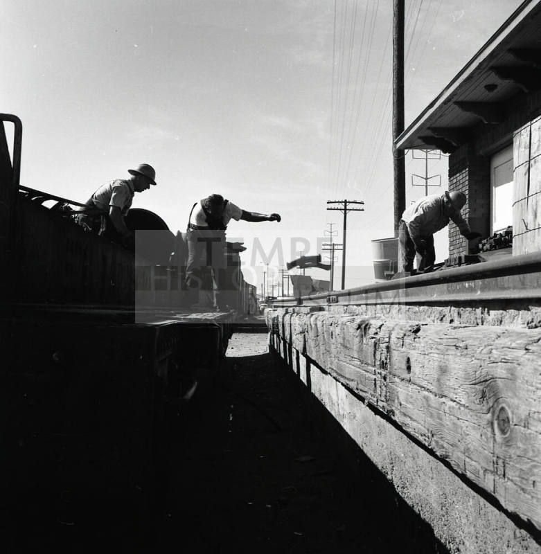 Freight transfer between flat car and Tempe Depot loading dock