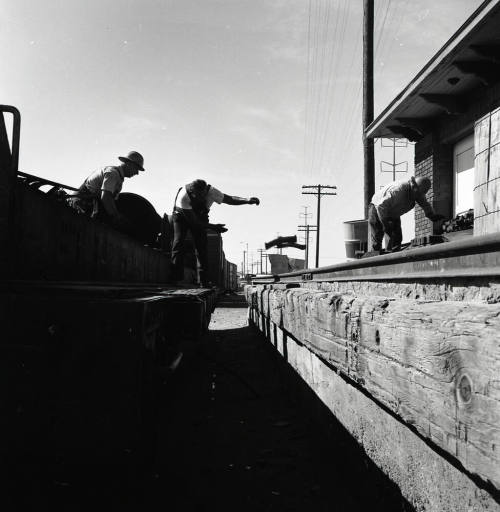 Freight transfer between flat car and Tempe Depot loading dock