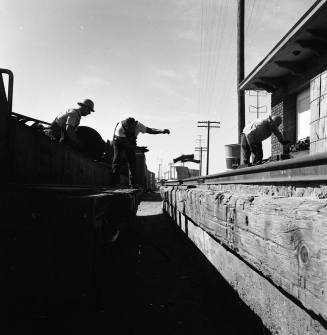 Freight transfer between flat car and Tempe Depot loading dock