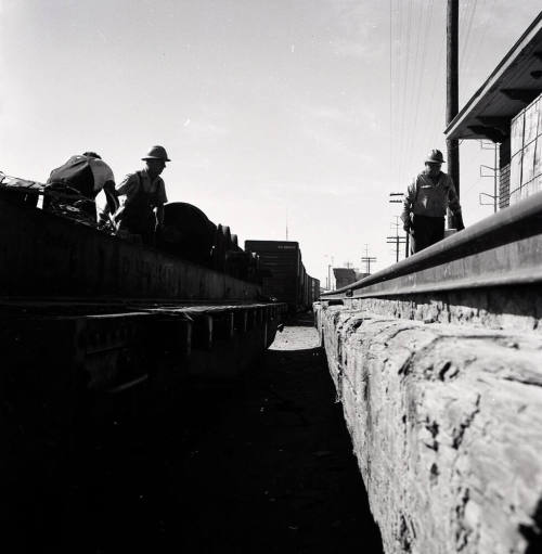 Freight transfer between flat car and Tempe Depot loading dock