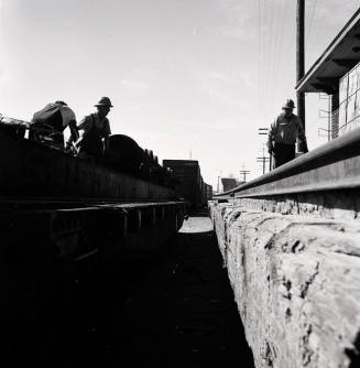 Freight transfer between flat car and Tempe Depot loading dock