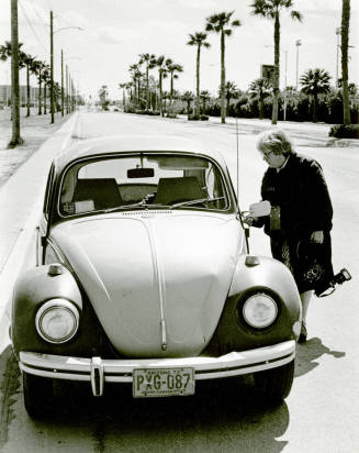 Jan Young in legendary raincoat by her VW bug.