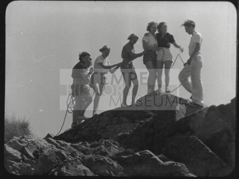 Black and whtie photograph: group of coeds climbing Tempe Butte
