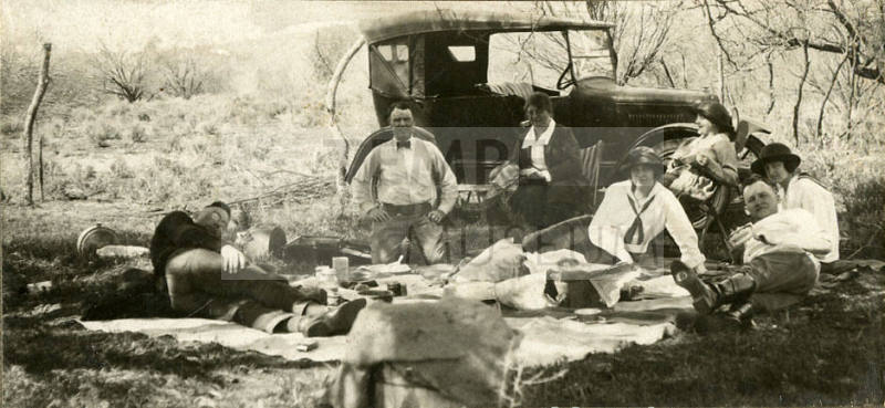 Photograph of people lying near a vehicle