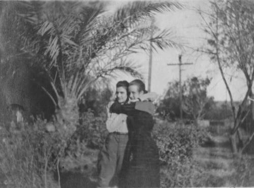 Girls hug near palm trees