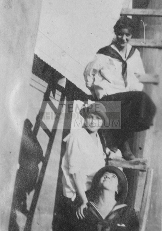 Three girls stading on wooden staris