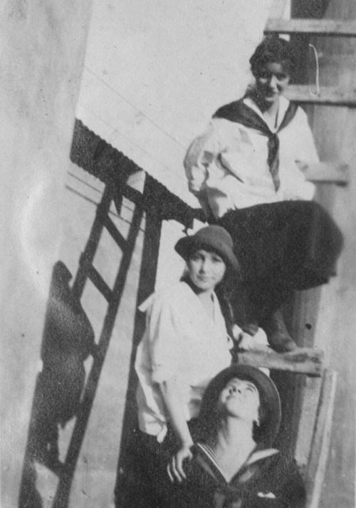 Three girls stading on wooden staris