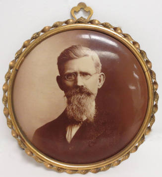 Portrait of man wearing glasses on button with frame