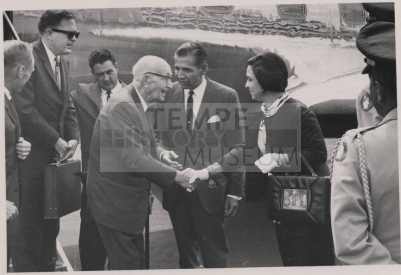 Carl shakes hands with a woman next to an Air Force plane