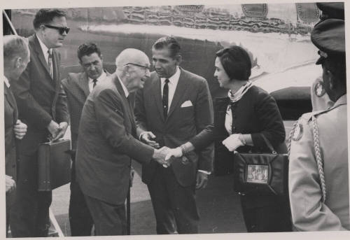 Carl shakes hands with a woman next to an Air Force plane