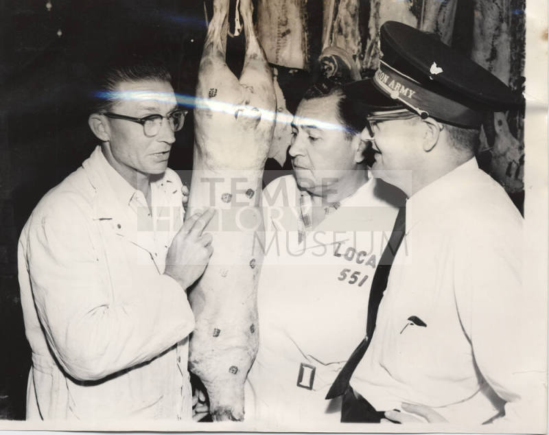 Men examining a butchered pig