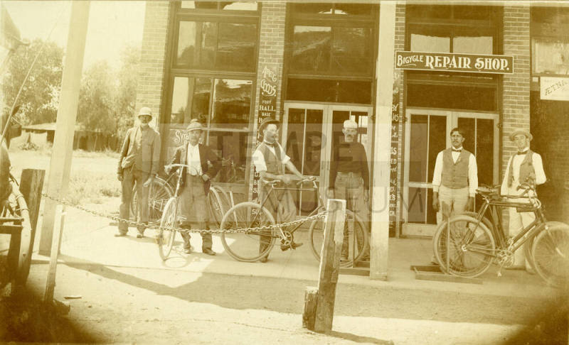 Chris Sigala and other men standing in front of Bicycle Repair Shop