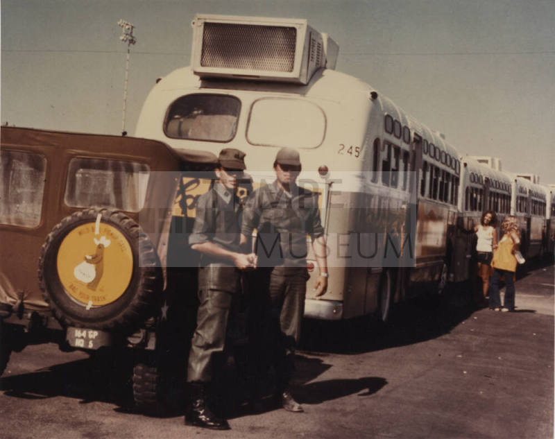 Two Military Personnel Standing by a Jeep