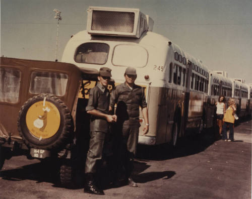 Two Military Personnel Standing by a Jeep
