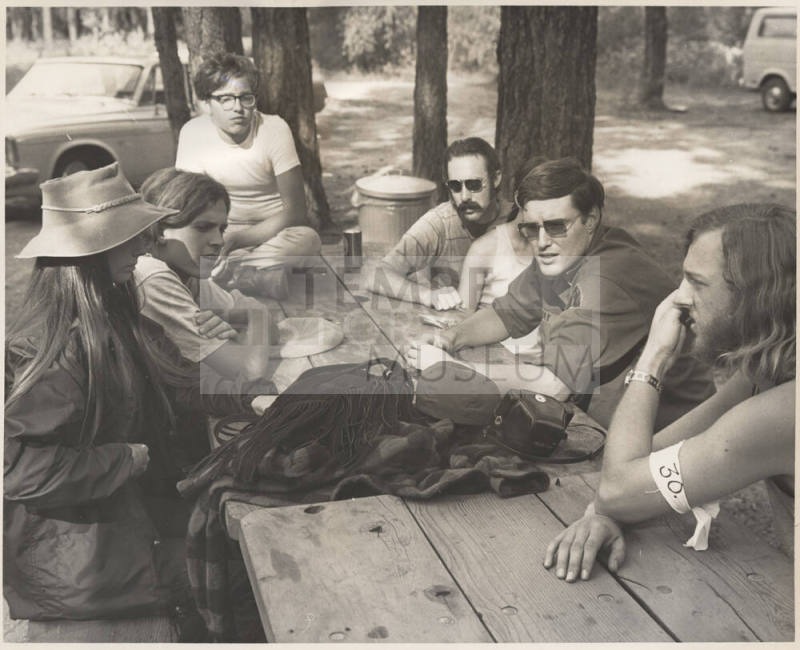 Photo of six people at picnic table in the woods