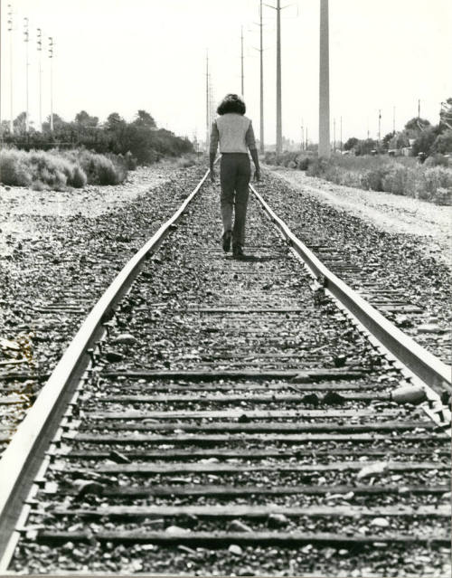 Person Walking Down Railroad Tracks