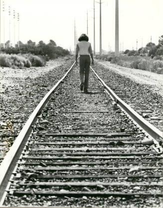 Person Walking Down Railroad Tracks