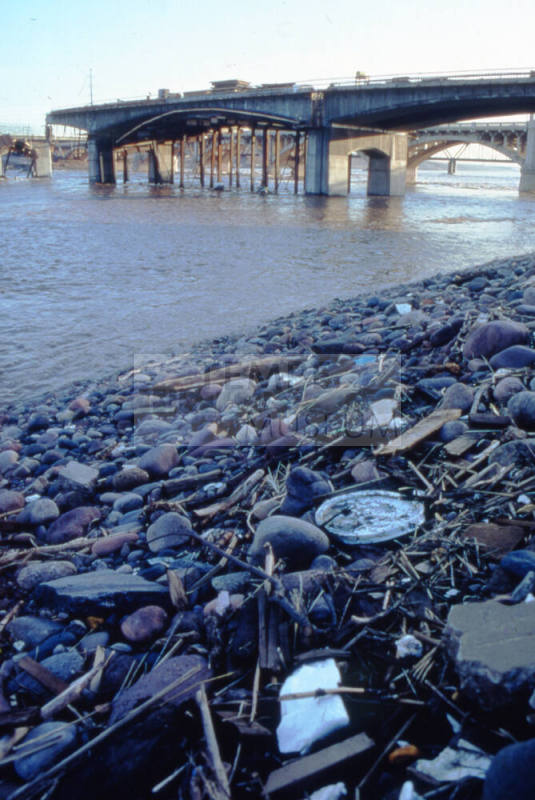 Receding flood waters with the damaged new Mill Avenue bridge in the background.