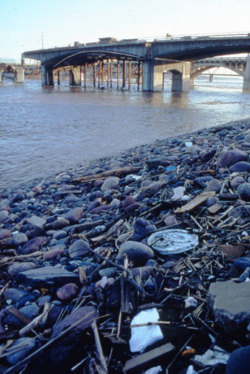 Receding flood waters with the damaged new Mill Avenue bridge in the background.