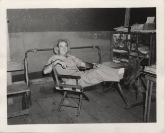 Man in Work Clothes in director chair