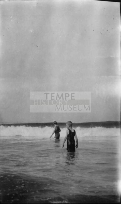 Image of a 2 boys wading into the ocean
