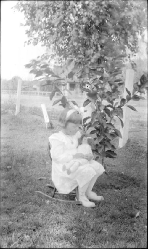Dorothy Woolf in rocking chair holding a doll