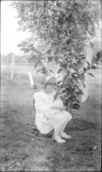 Dorothy Woolf in rocking chair holding a doll