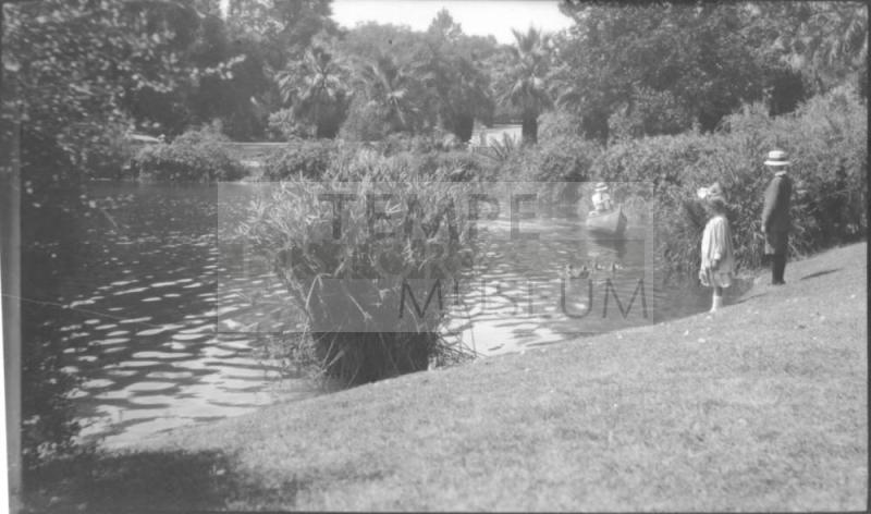 Charles Custis padding a canoe with Charles Harold and Dorothy watching