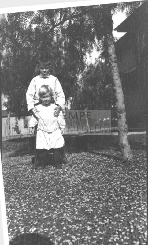 boy and younger child in field of flowers
