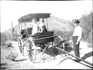 Dorothy and dog in covered wagon in desert