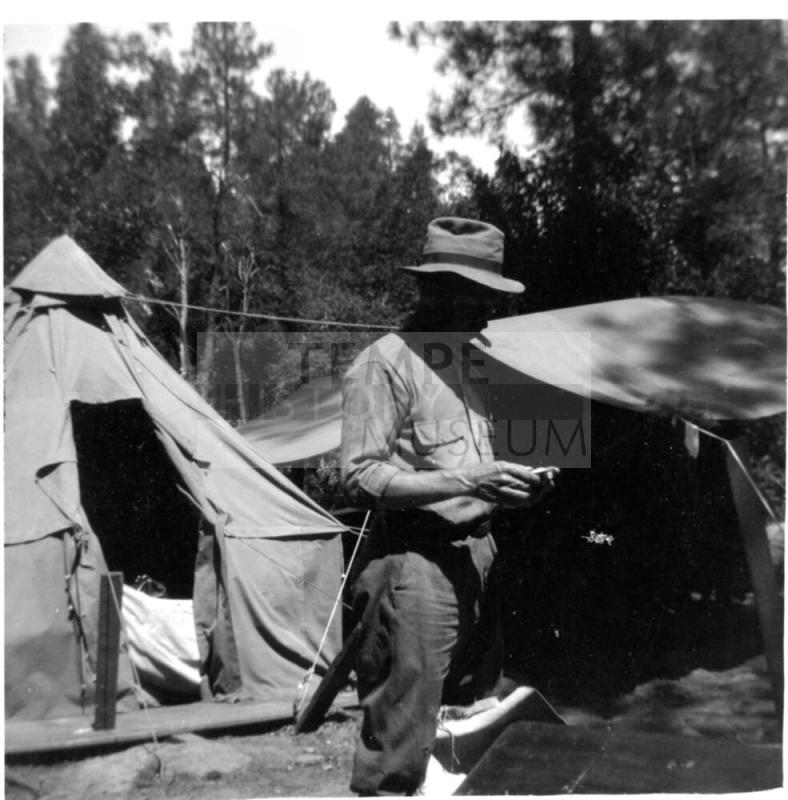 Charles Custis in front of tents
