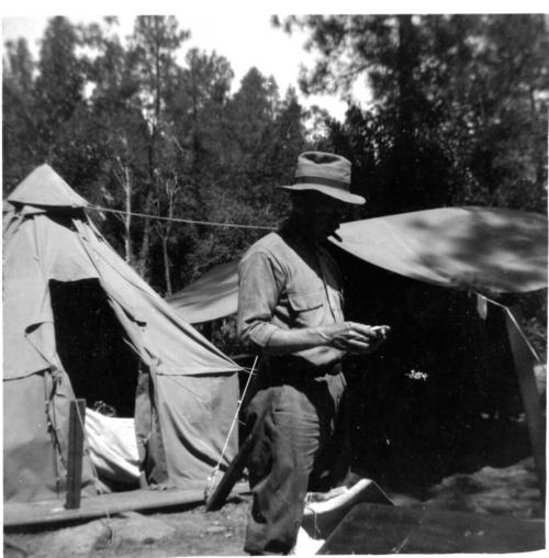 Charles Custis in front of tents