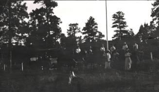 unknown people posing in front of pine trees
