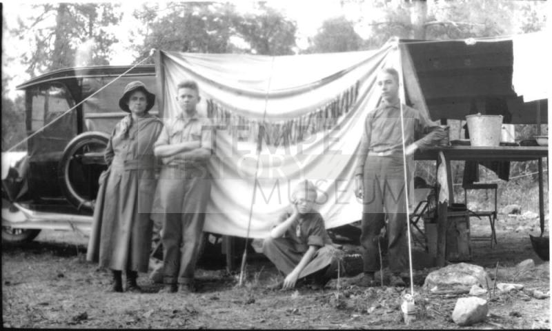Ruby, Charles Harold, and Dorothy, and young man at campsite chuckwagon