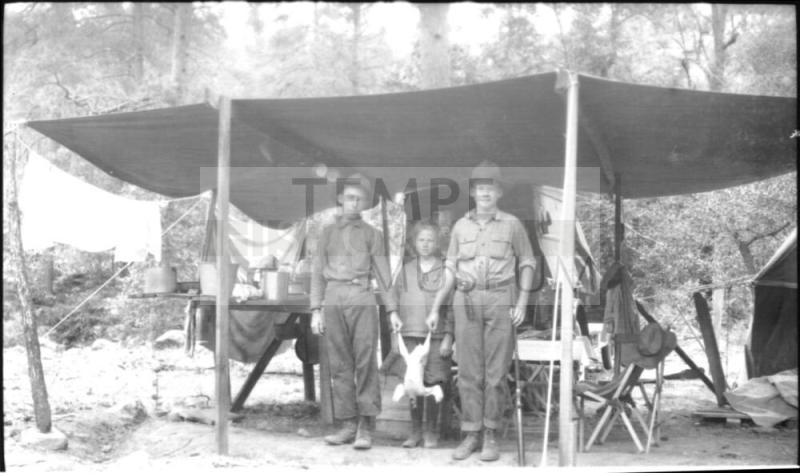 Charles Harold, Dorothy and cousin Bill (?) at campsite chuckwagon with chicken carcass