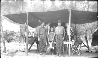 Charles Harold, Dorothy and cousin Bill (?) at campsite chuckwagon with chicken carcass