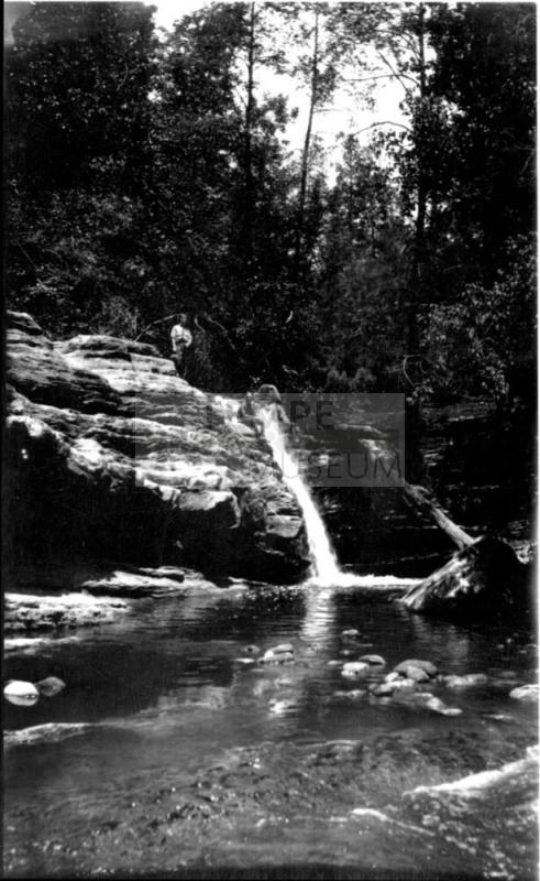 waterfall, with 2 figures standing on top