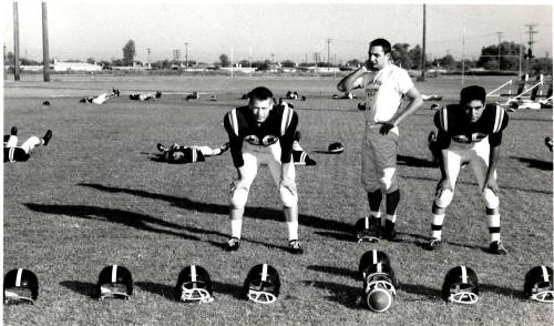 Photograph of Tempe Union Football Players Surrounded by Empty Helmets