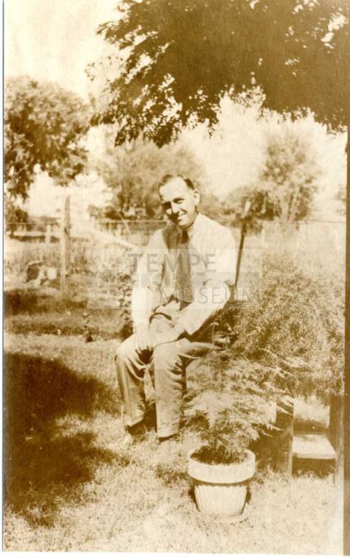 Photo of man sitting under a tree