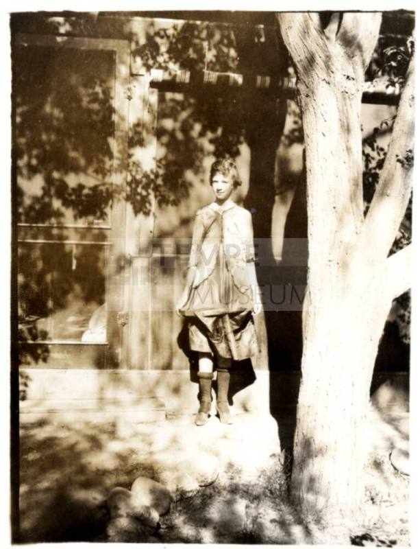 Picture of Ruby Laird Leaning on a Building under a  tree