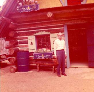 Frank Raymond Outside a Log Cabin Store