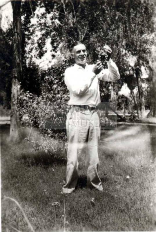 Frank Raymond Holding a Bunch of Grapes