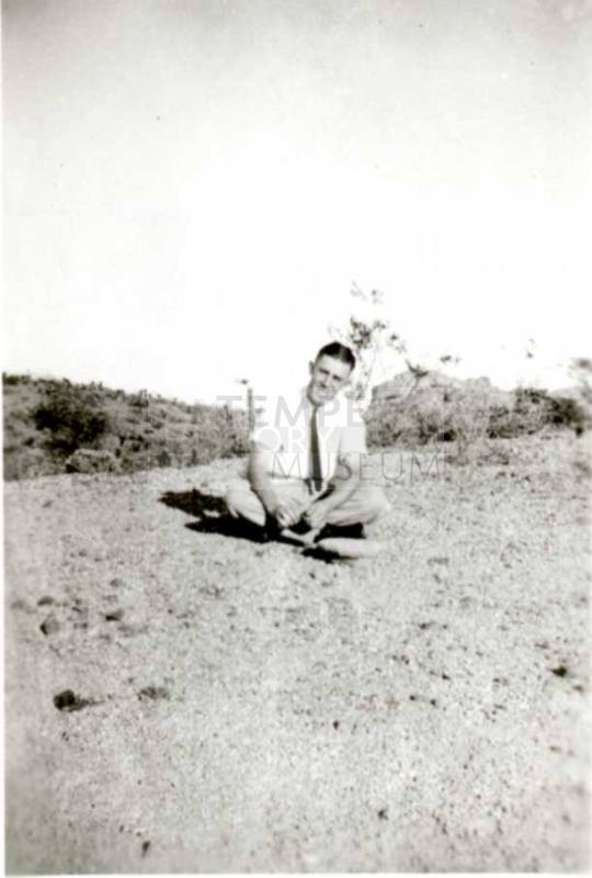 Frank Raymond sitting cross-legged on the ground