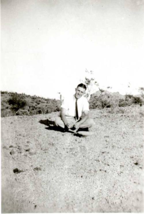 Frank Raymond sitting cross-legged on the ground