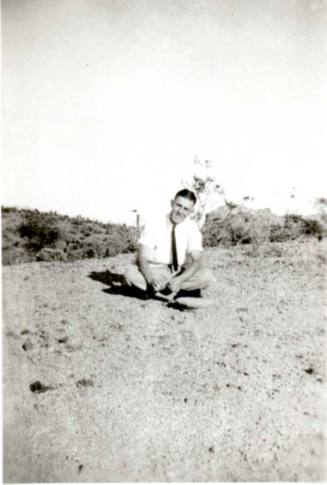 Frank Raymond sitting cross-legged on the ground