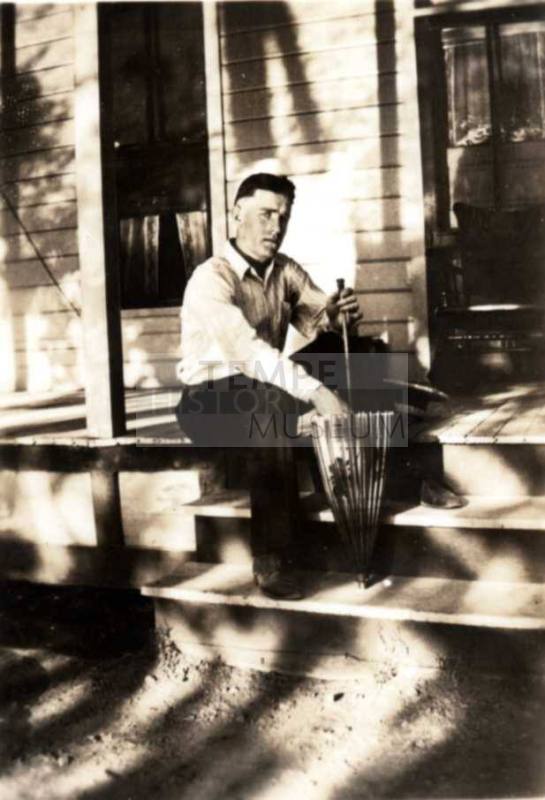 Frank Raymond Sitting on Front Porch with an Umbrella