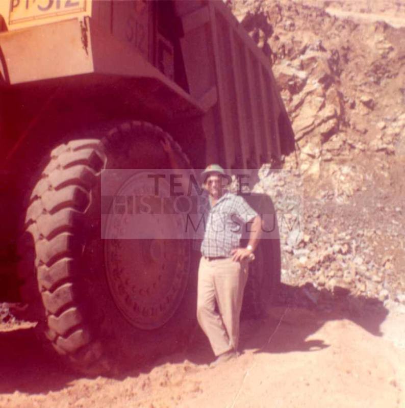 Jim Raymond Stands Next to a Large Vehicle