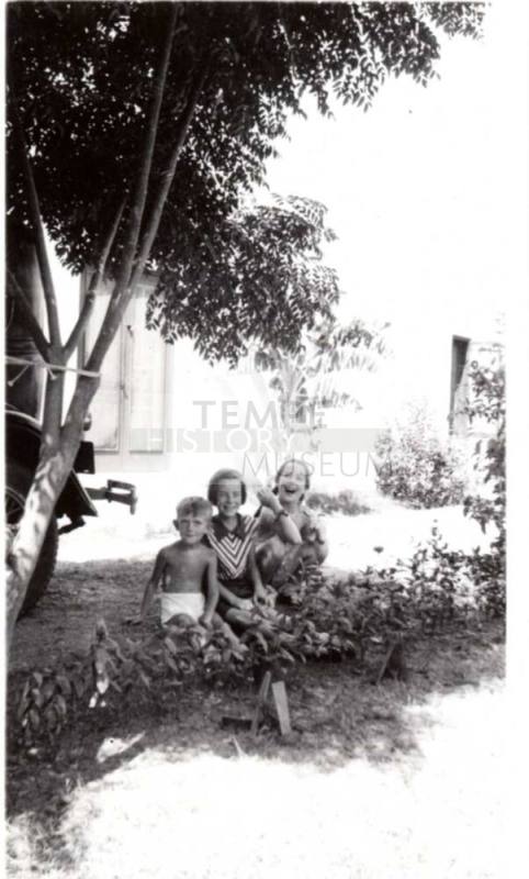 Bill and JoAnne Raymond with Jo Ann Dewey Behind Shrubs